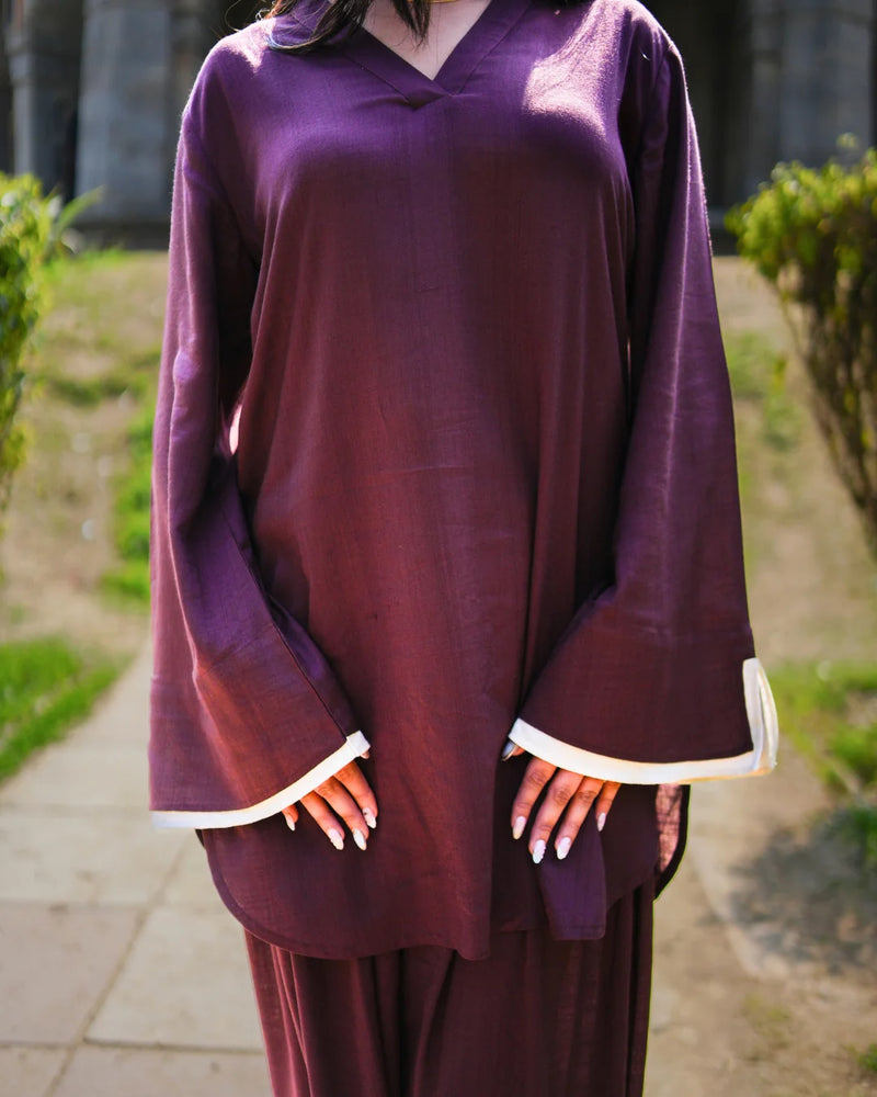 Person wearing a purple outfit with white trim in an outdoor setting