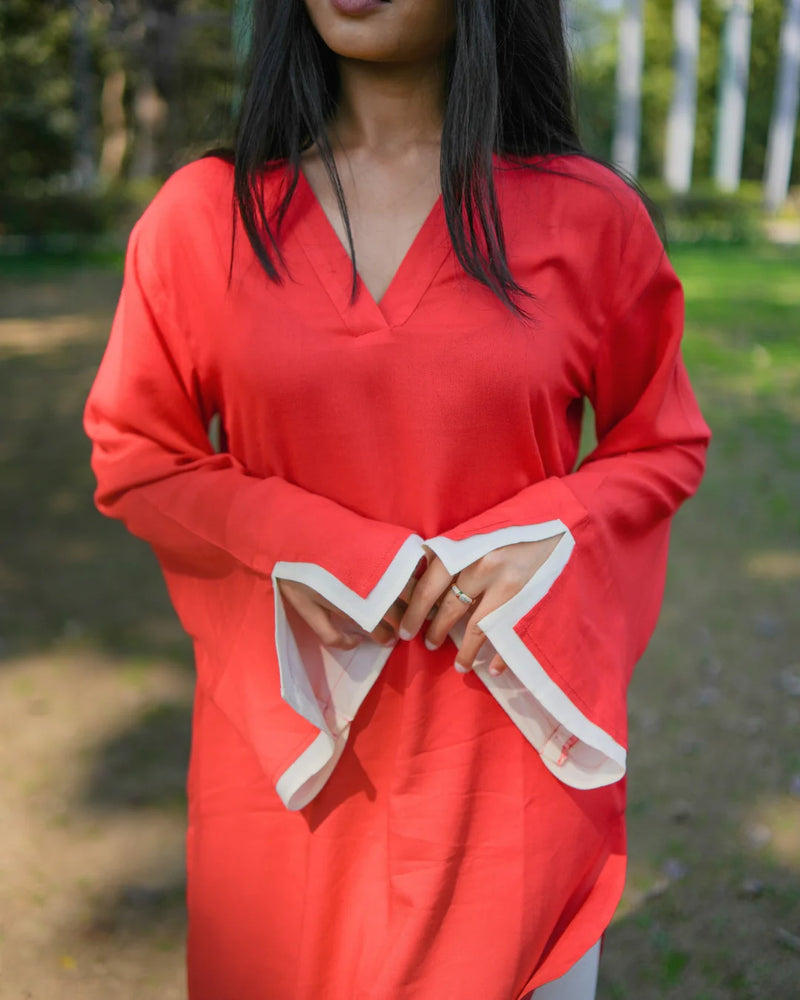 Person wearing a red dress with white trim in an outdoor setting