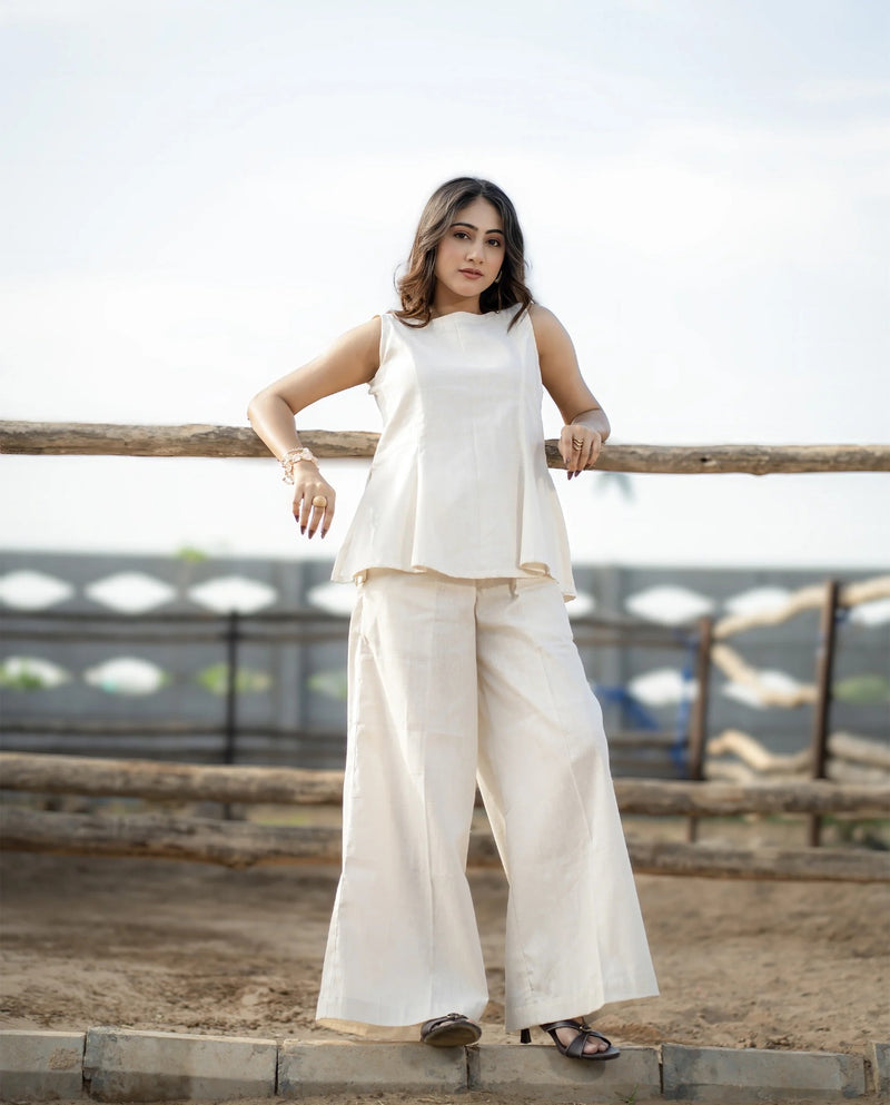 Woman in a white outfit standing on a wooden platform with a blurred background